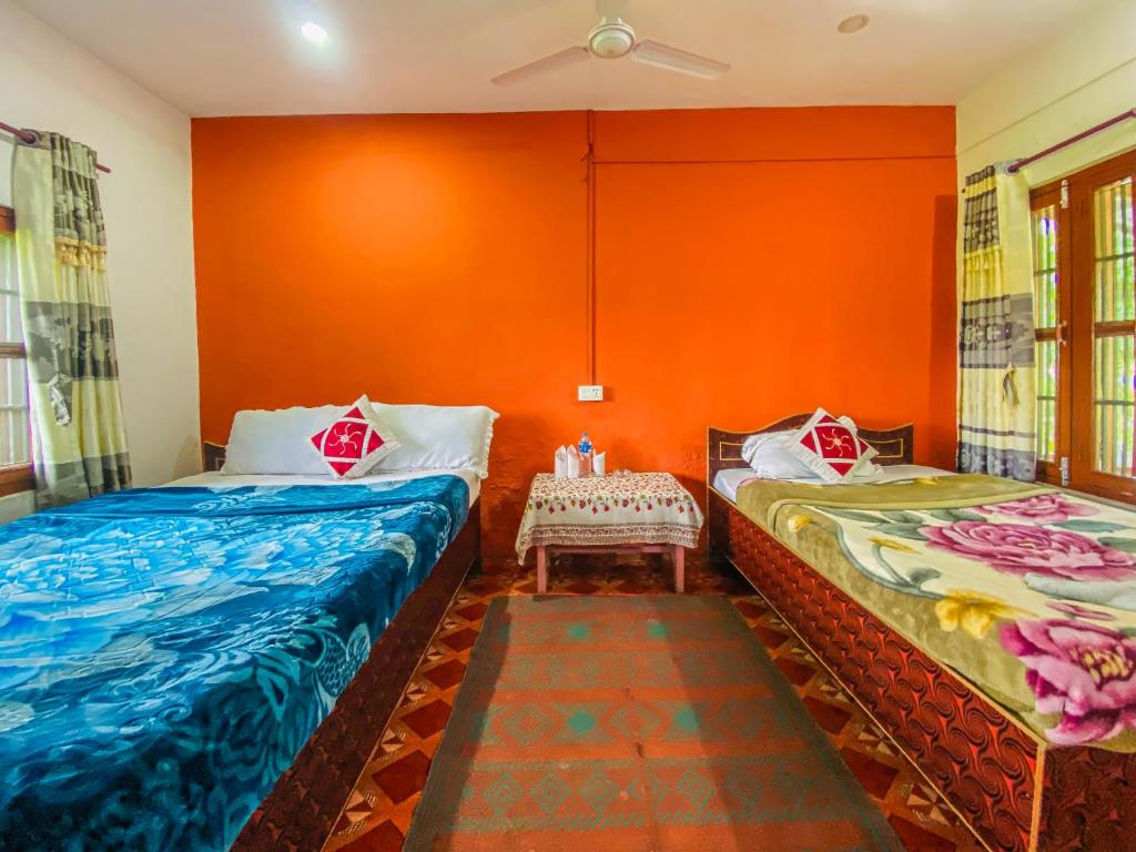 Room with twin beds, coat rack, and orange walls
